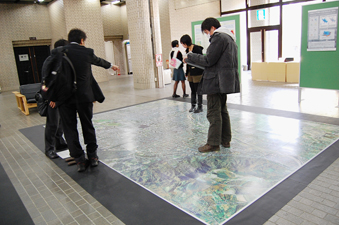 札幌市の空中写真の上を歩く来場者