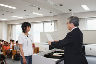 賞状を授与する脇田理事・副学長