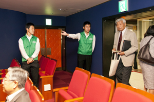 会場内で案内する学生ボランティア