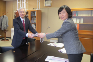申教授(右)から記念品を受取る小内研究院長(左)