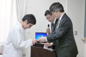 ネームプレートを手渡す南薬学部長