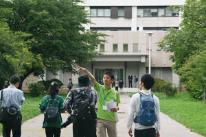 現役学生スタッフによるガイドを真剣に聞き入る同窓生
