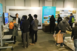 展示について説明する北大生とツアー参加者の様子