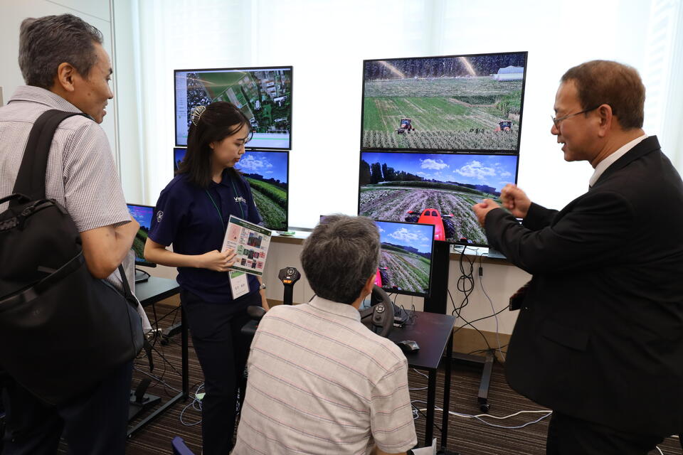北大の農場にあるトラクターを東京の会場から遠隔操作する「スマート農業」のデモンストレーションの様子