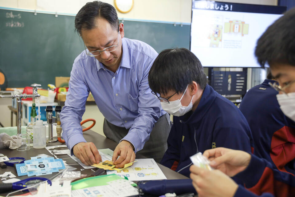 生徒と顕微鏡を組み立てる大場教授