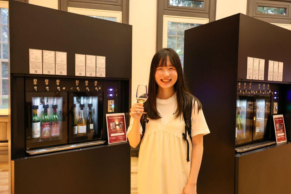 北大の余市果樹園で採れたブドウを使ったロゼワインを手にする学生(撮影:長尾 美歩)