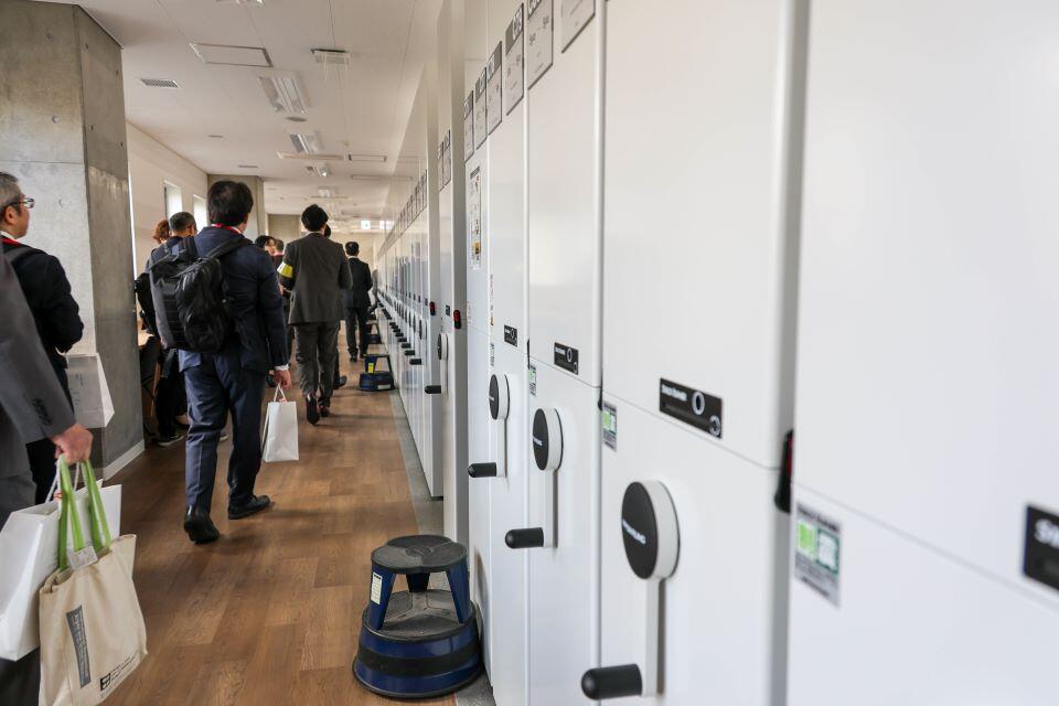 手動式の集密書架が導入された書庫。窓側は学習スペースで、窓の外には桜の木が並ぶ(撮影:長尾 美歩)