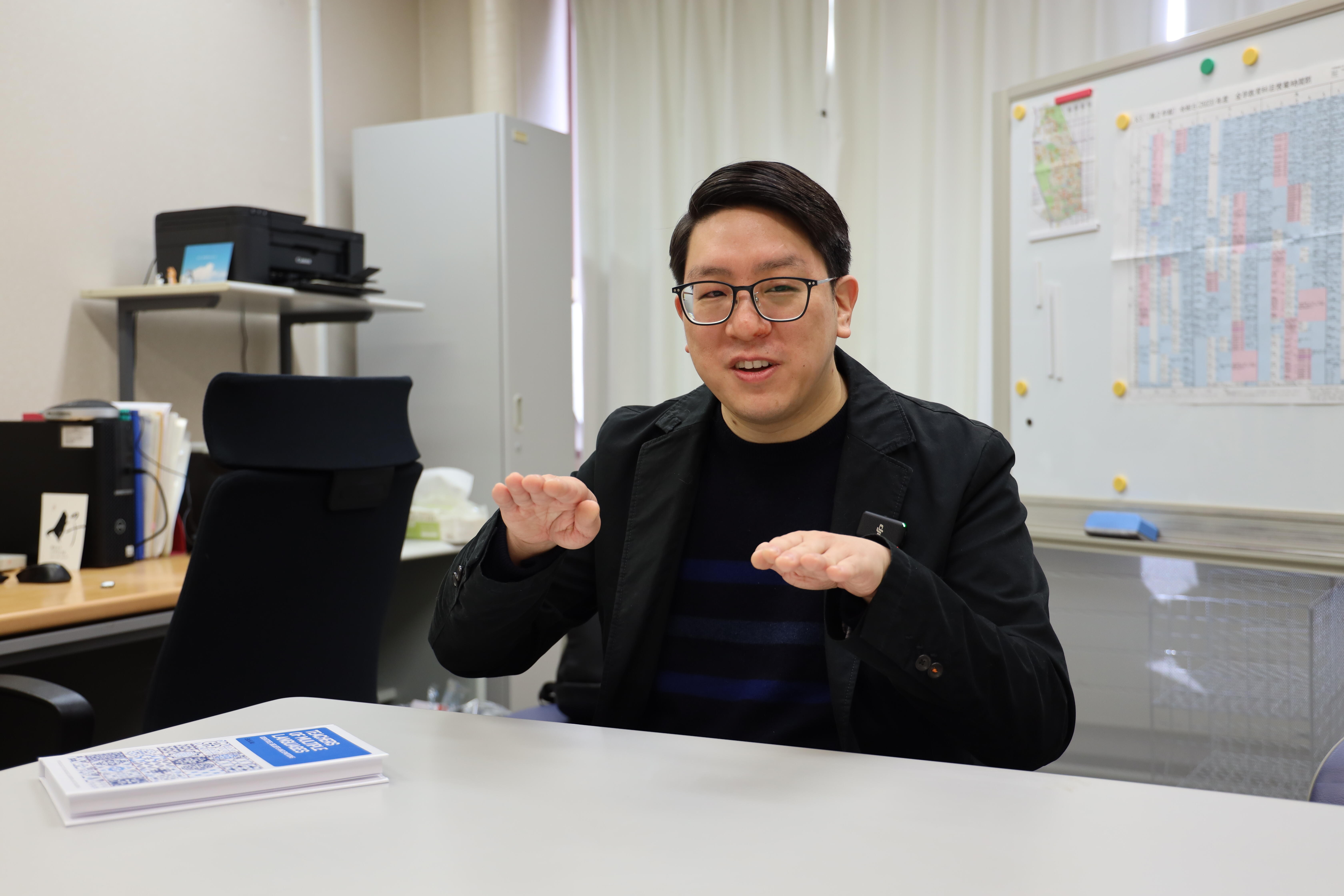 言語学研究の複雑さを説明するクーさん （撮影： Sohail Keegan Pinto）