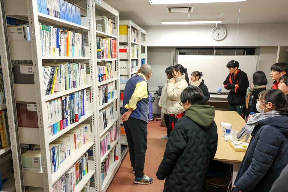 研究室で書庫を見学する生徒たち。多くの本に興味を惹かれる生徒も