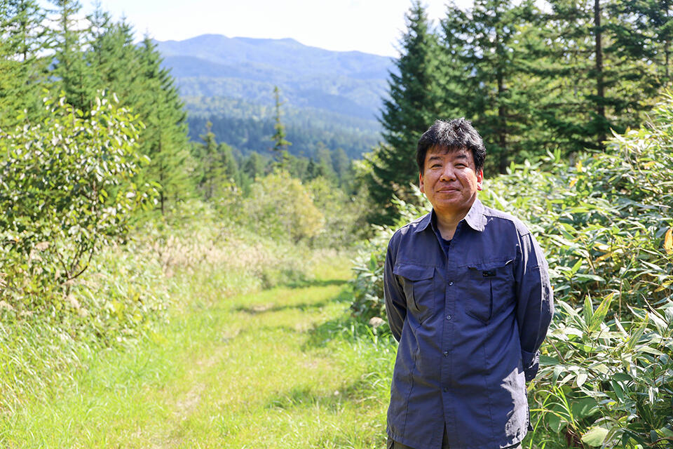 北方生物圏フィールド科学センター 天塩研究林長の高木健太郎 教授。遠くに見える山々まで、すべて天塩研究林の風景