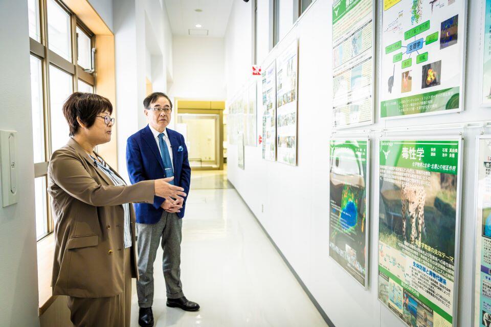 毒性学について寳金総長に説明する石塚教授(左端)