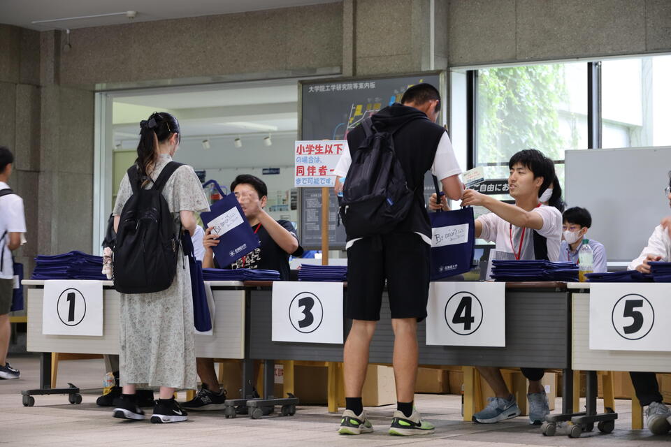工学部の受付で資料を受け取る高校生たち
