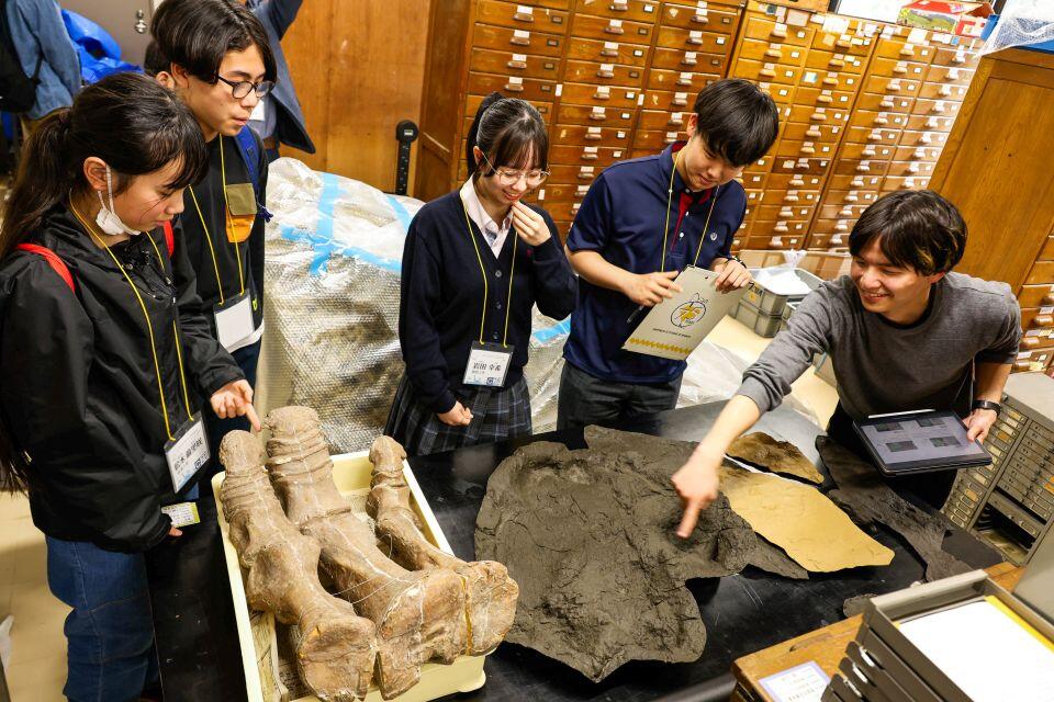 普段は非公開の収蔵室にて。発掘現場で型をとった恐竜の足跡の大きさに驚く参加者