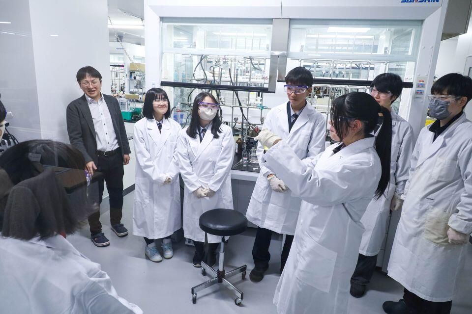 実際に実験室を見学して化合物に触れてみる生徒たち