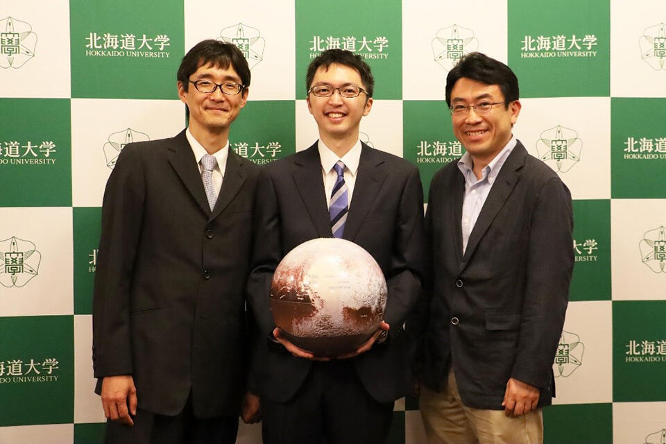 冥王星の模型と一緒に。左から、谷准教授、鎌田准教授、倉本教授