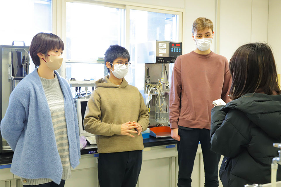 研究室の学生をインタビューする立花さん（右端）