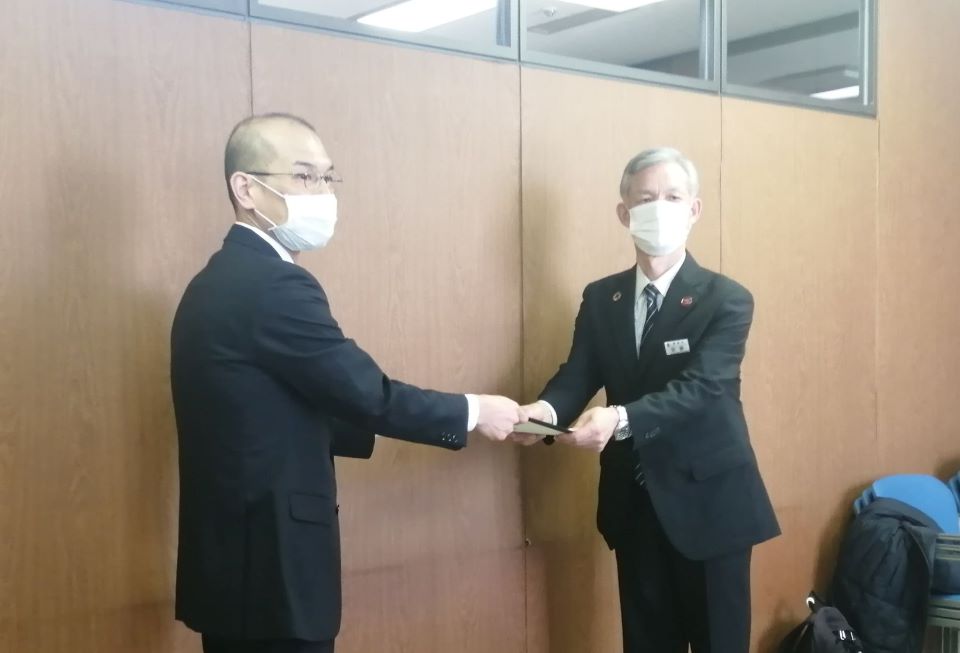 札幌市の環境局長(右)に「気候市民会議さっぽろ2020」の報告書を手渡す三上 直之 准教授(左)